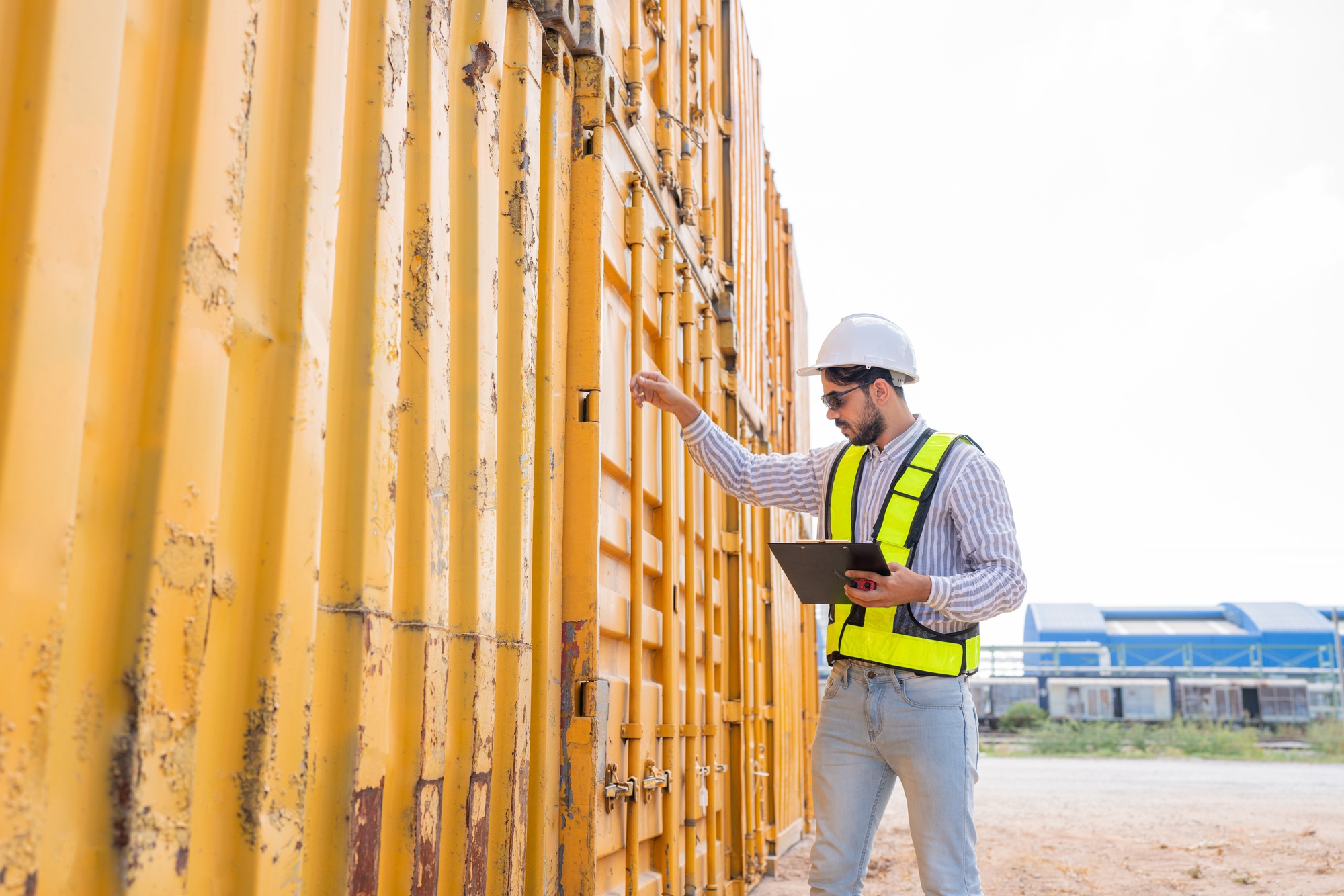 Container yard worker checking container at container yard warehouse.