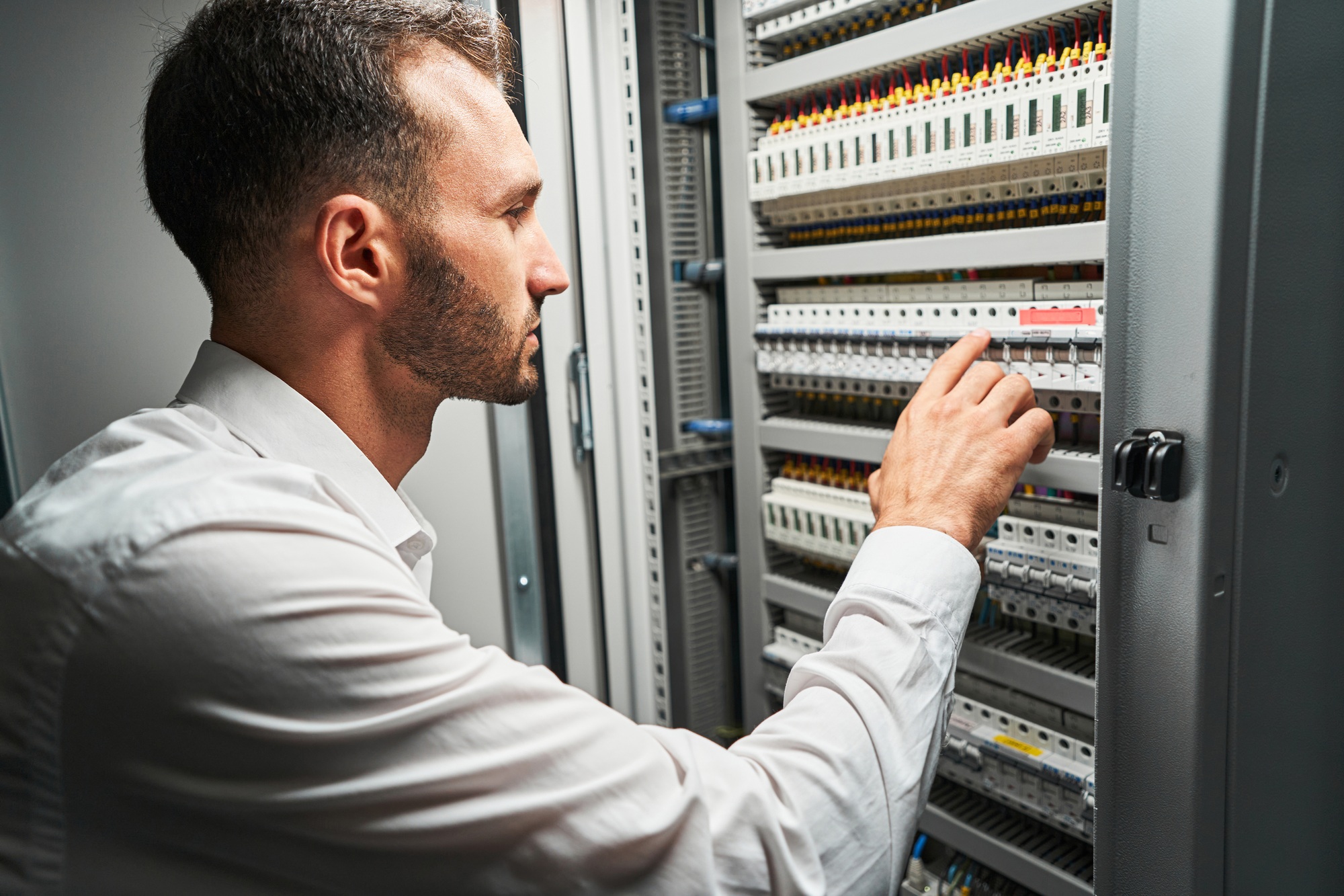 Man system administrator pressing on electrical switch
