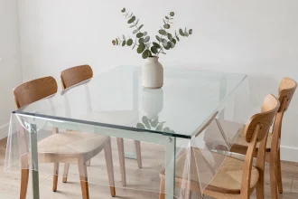 Toile cirée épaisse transparente posée sur une table en verre dans une salle à manger minimaliste scandinave